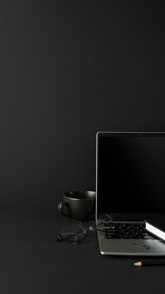 Privacy computer setup with Dell laptop, coffee and glasses on a dark desk